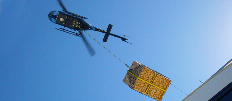Helicopter using a longline and cargo net to transport a load
